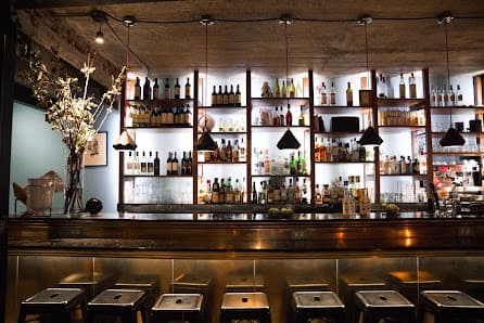 Bar interior at Farina Polanco, showing backlit spirit shelves and intimate seating
