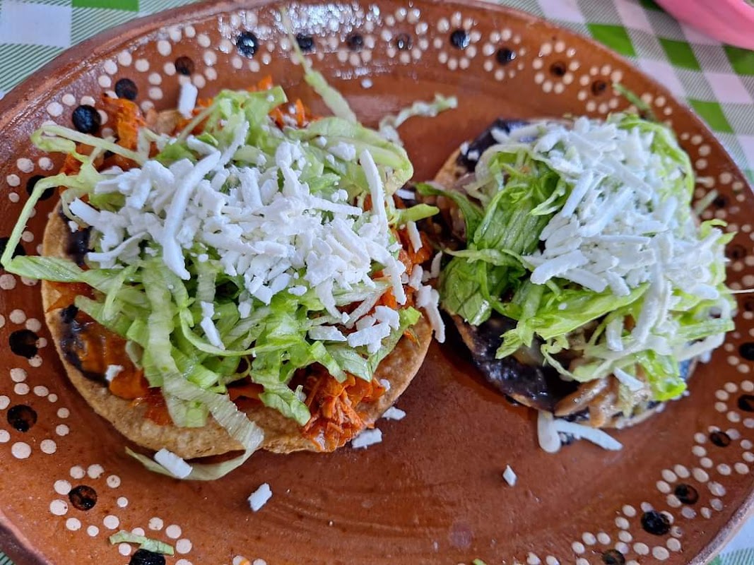 Gordita rellena de chicharrón en La garnacha feliz, mostrada en la barra con salsas coloridas al lado