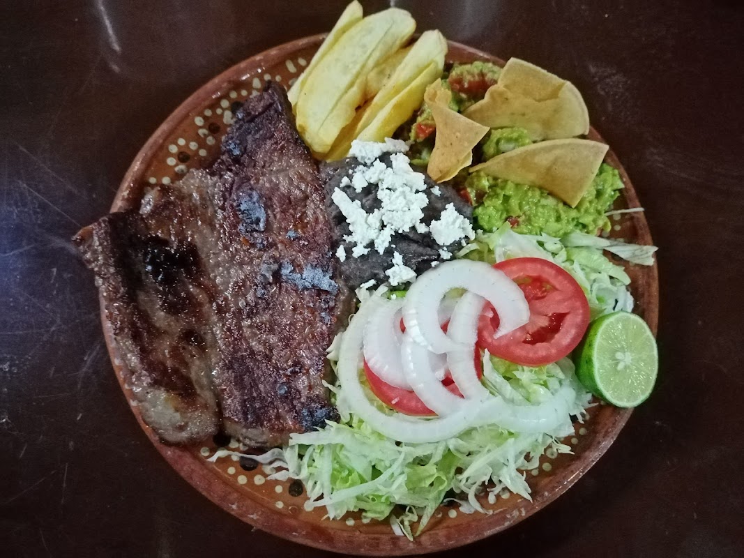 Gorditas Y Migadas "Doña Olga" – mostrando una gordita de guisada y una migada de asada en un plato de barro, dentro del local en Calle 4 de junio