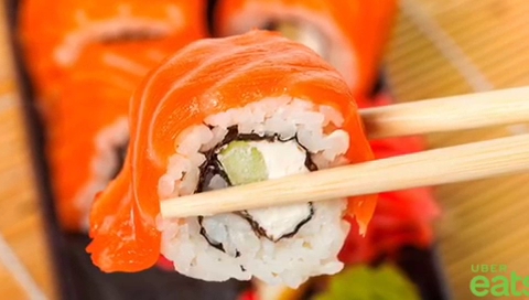 Fachada de Sushi Maki en Av. Antonio de Deza, con su letrero luminoso y una mesa mostrando una variedad de maki rolls.