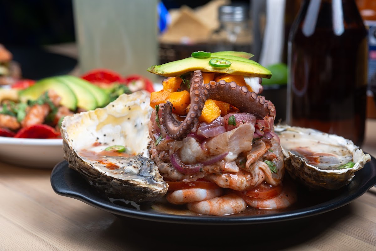 A bustling seafood counter at Mariscos La Cuichi with sizzling dishes and fresh ingredients