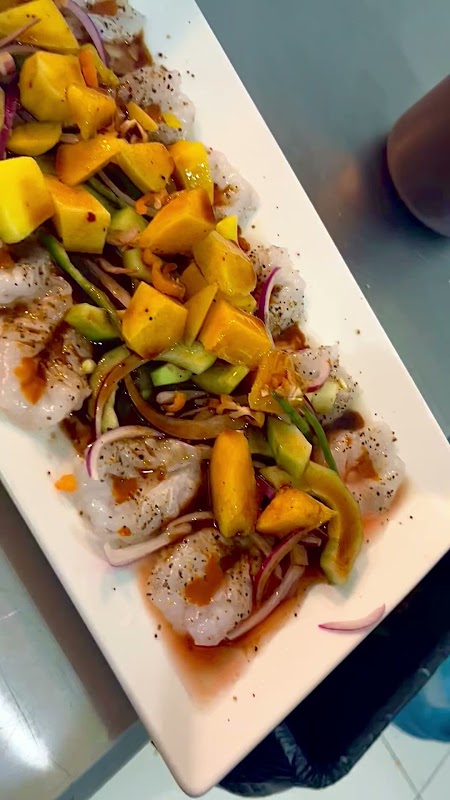 Pescado frito con salsa de mango en La Iguana Mariscos — captura del plato crujiente sobre bandeja
