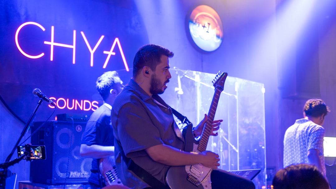 A man sitting on a stool playing a guitar