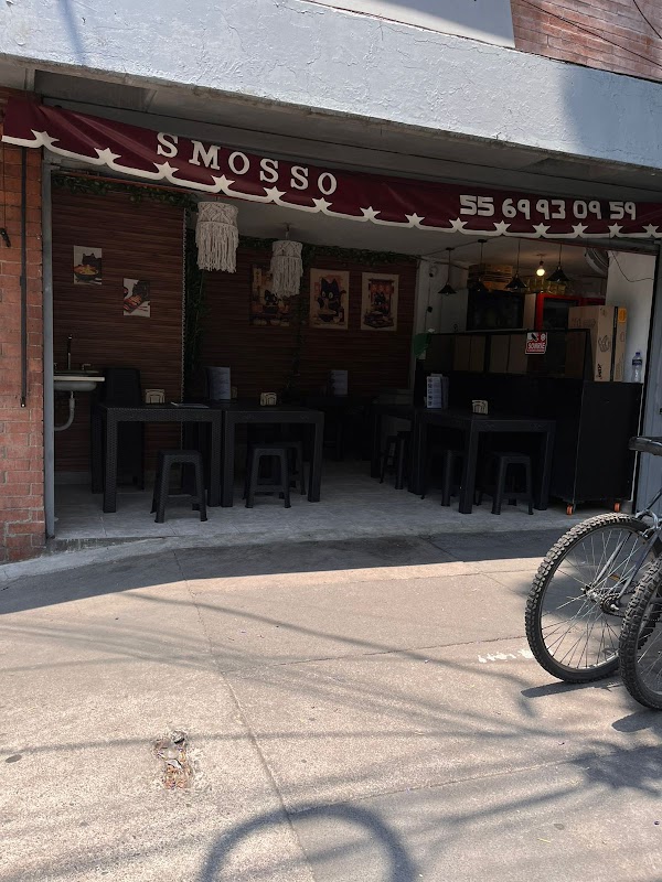 Exterior de Moshi Moshi con su letrero rojo y una mesa con sushi y ramen al frente