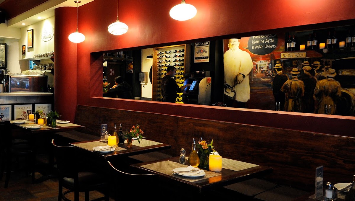 Interior de Argentalia con mesas de madera y una placa de risotto de setas humeante en primer plano