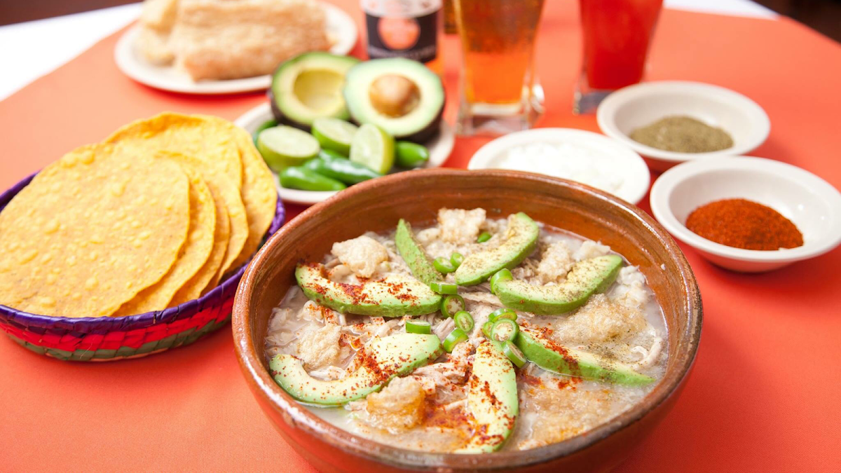 Traditional clay pozole bowls with pork and toppings at Casa Licha Pozole