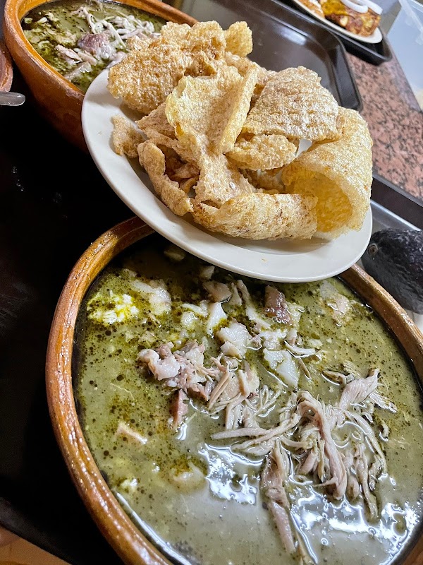 Casa Licha Pozole serving a steaming bowl of pozole rojo with pork and cacao broth, close-up
