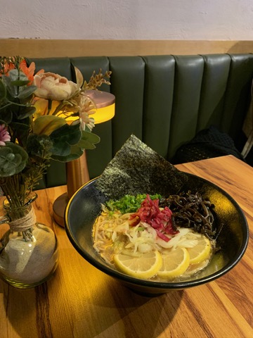Primer plano del ramen con huevo marinado y trozos de pollo naranja en Vegan Ramen Mei Del Valle