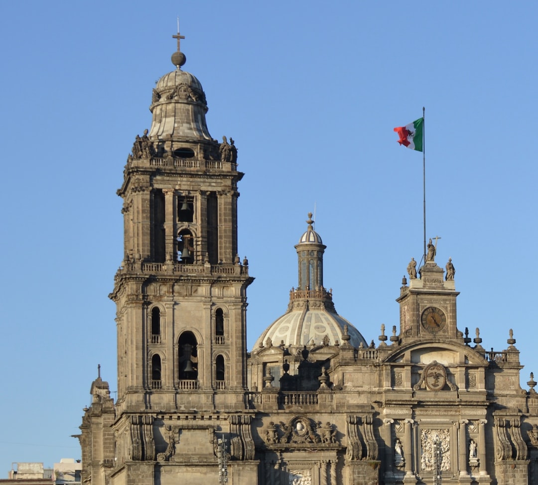 Historic cathedral with mexican flag under blue sky