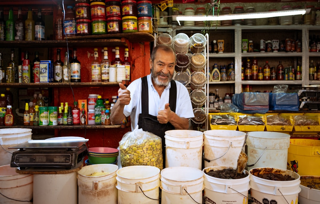 Man behind a market stall with buckets and thumbs up