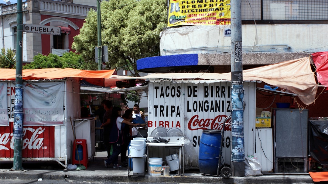 people standing near white and blue signage during daytime