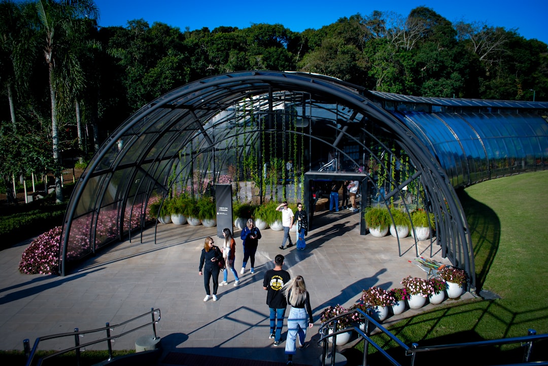 a group of people walking around a large greenhouse