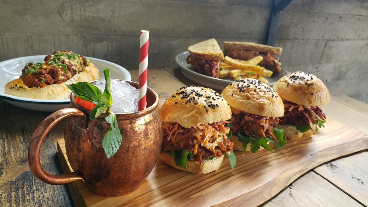 Exterior de Old Peter con iluminación cálida y clientes en terraza