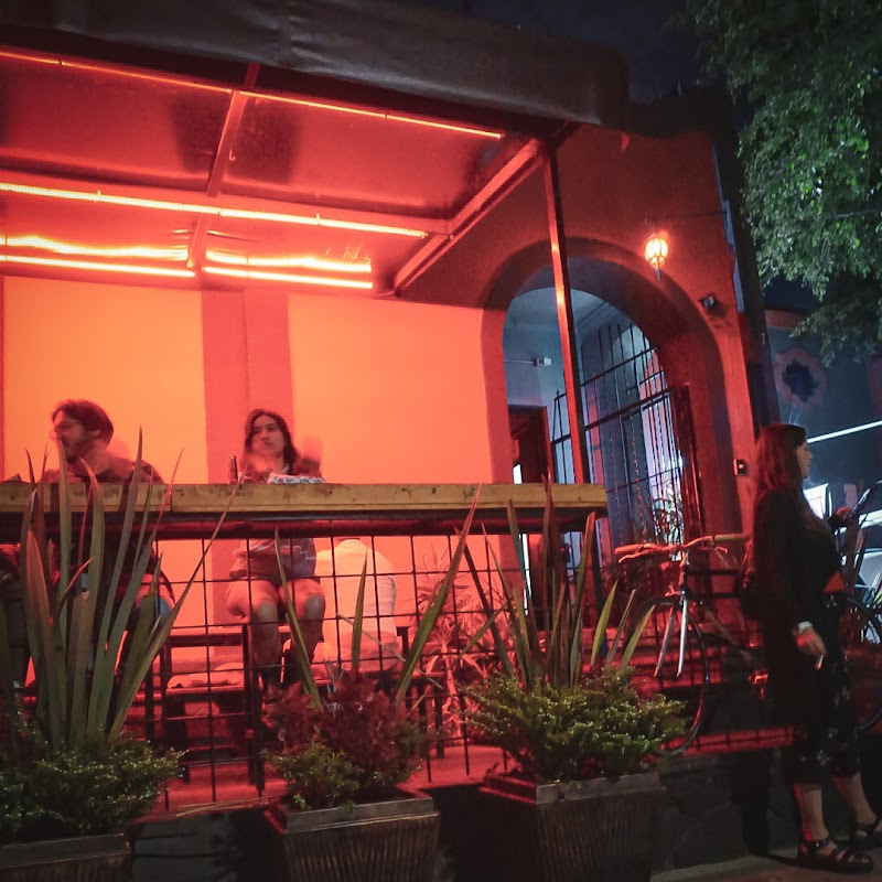 Interior de Pigalle con iluminación cálida y mesas de madera