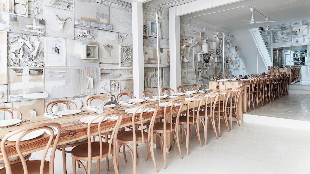 Interior de Hueso Restaurante con mesas compartidas y luces cálidas