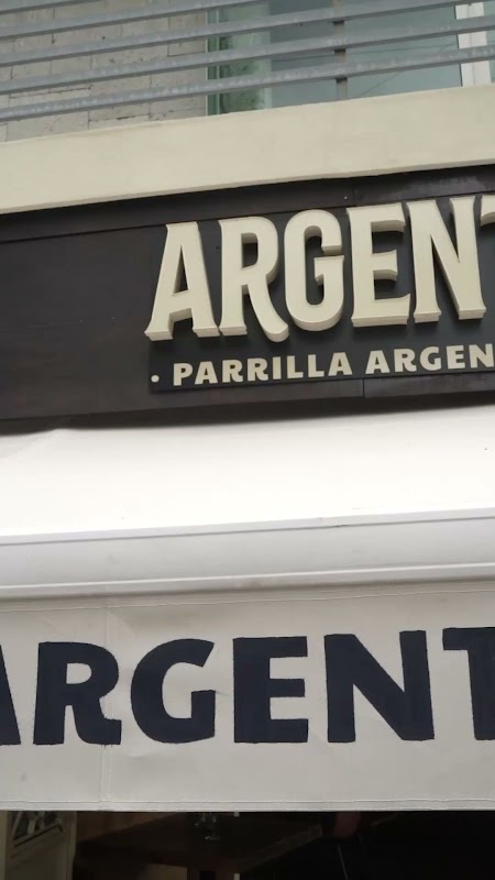 Argento Americana’s grilled rib and choripán on a wooden board — interior view of the Americana street façade