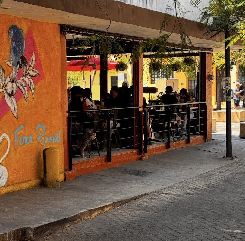 Interior de Louis Café con mesas de trabajo, café en taza y waffle de matcha en primer plano