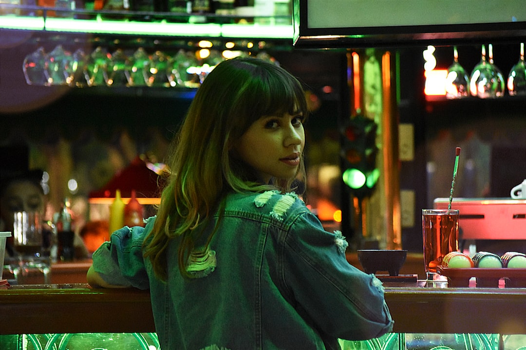 woman in green hoodie standing near counter