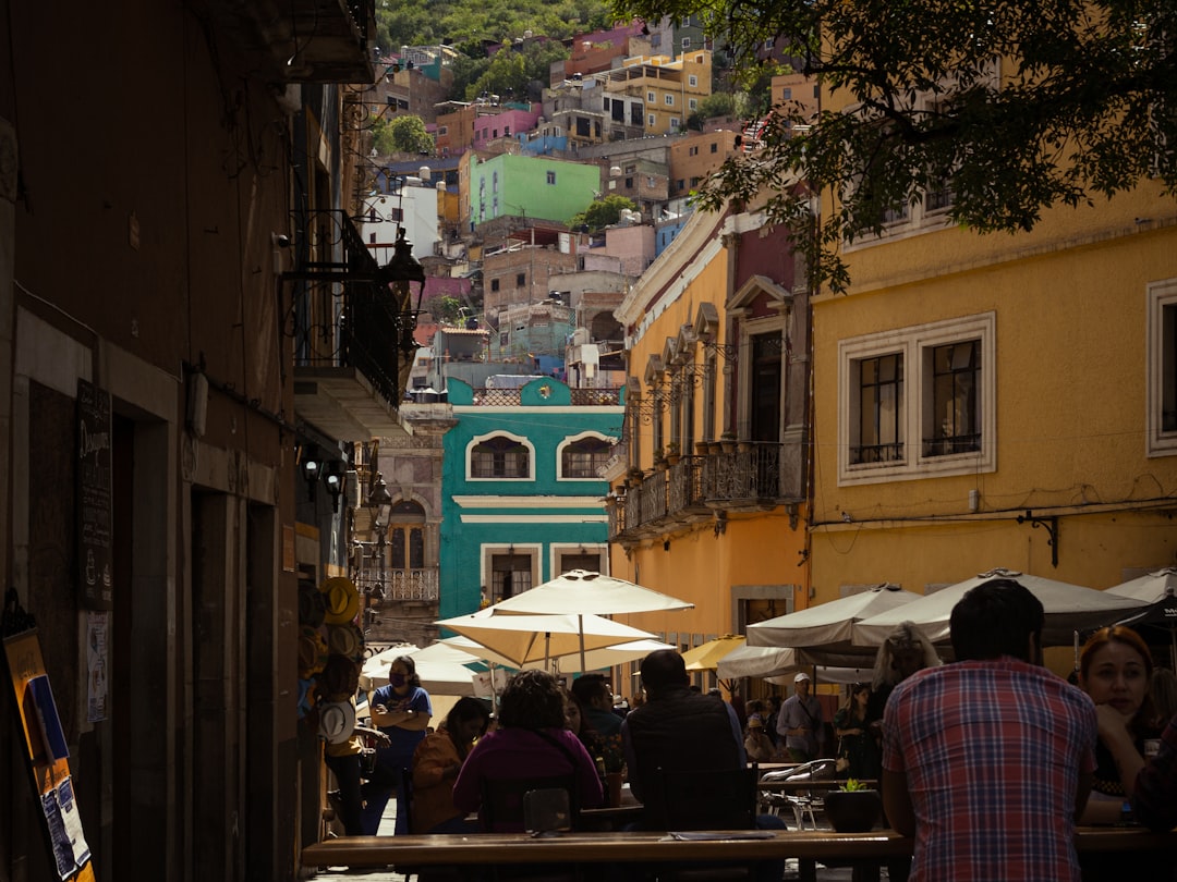 A group of people walking down a street next to buildings