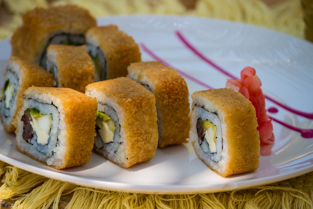 A white plate topped with sushi rolls on top of a table