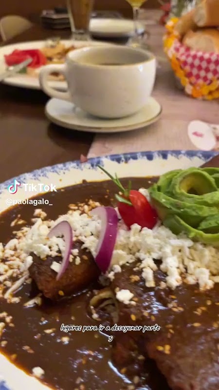 Plato de chilaquiles verdes con huevo en Las Tías — primer plano del plato y fondo del comedor del centro