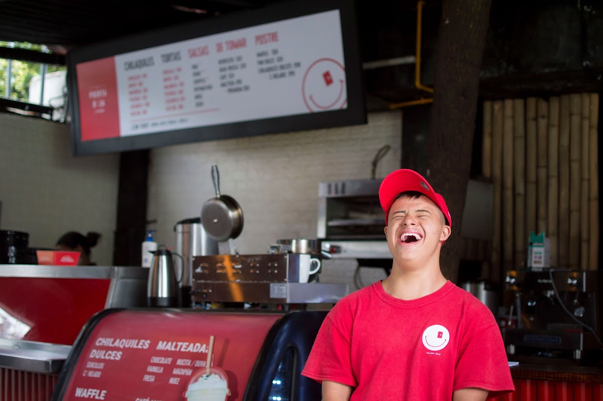 El Braserío exterior con su letrero rústico y una parrilla mostrando un rack de cabrito chisporroteante