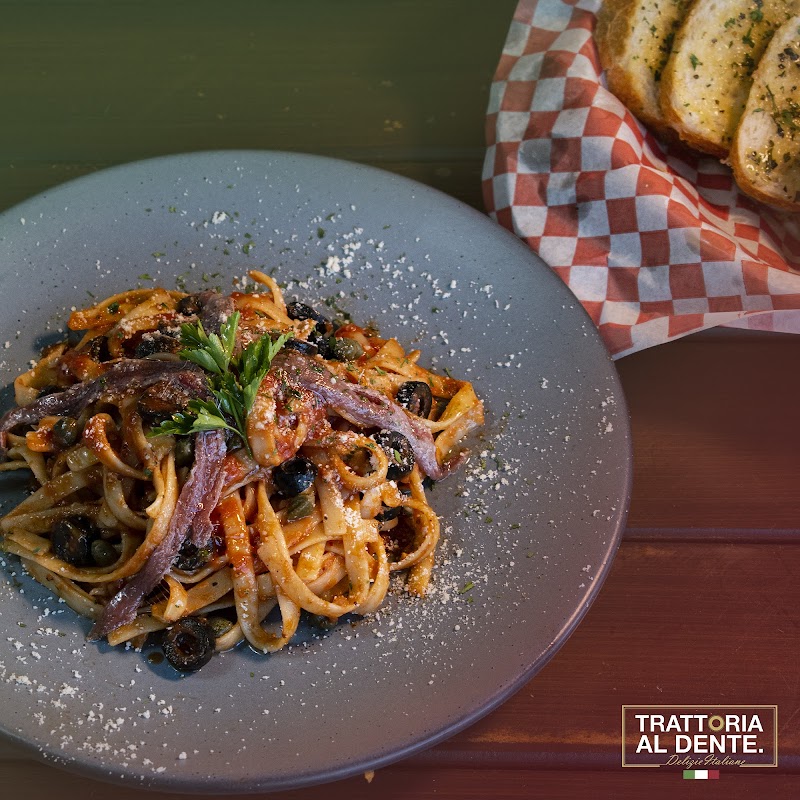 Interior de Trattoria Al Dente con barra de pastas y camareros sirviendo ravioli, luz cálida y mesas de madera