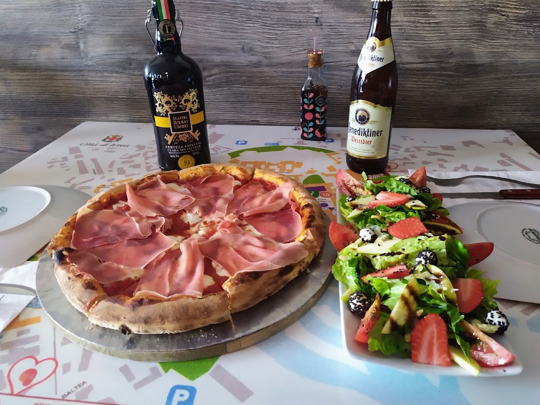 Pizzeria La Bella Ivrea’s wood‑fired oven and a freshly pulled quattro formaggio pizza on a wooden board