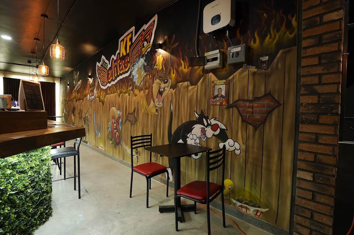 KFAlitas Jardines del Río – foto del mostrador con alitas crujientes y una hamburguesa, luz cálida interior