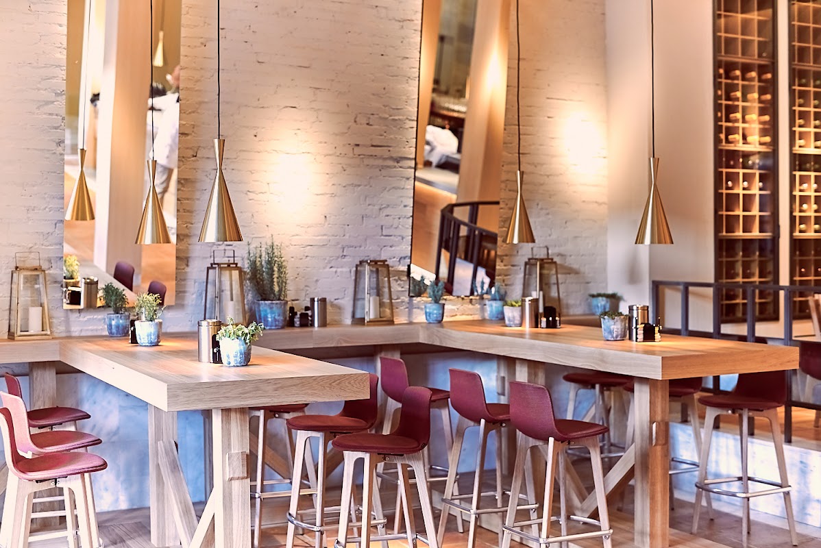 El ambiente interior de Marcela Brasa y Vinos con mesas y plantas