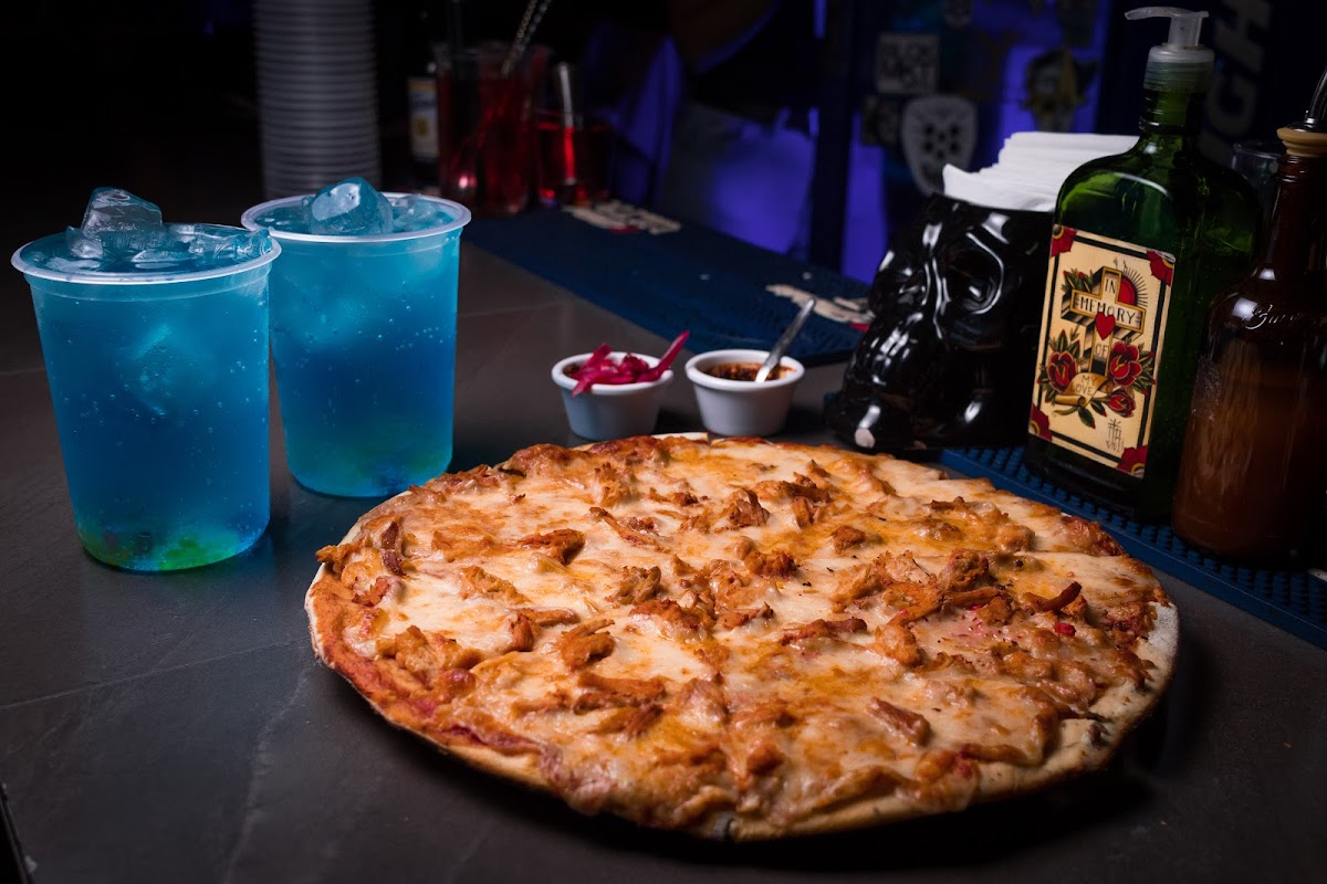 Interior de Chabola Bar con luces neón y clientes bailando