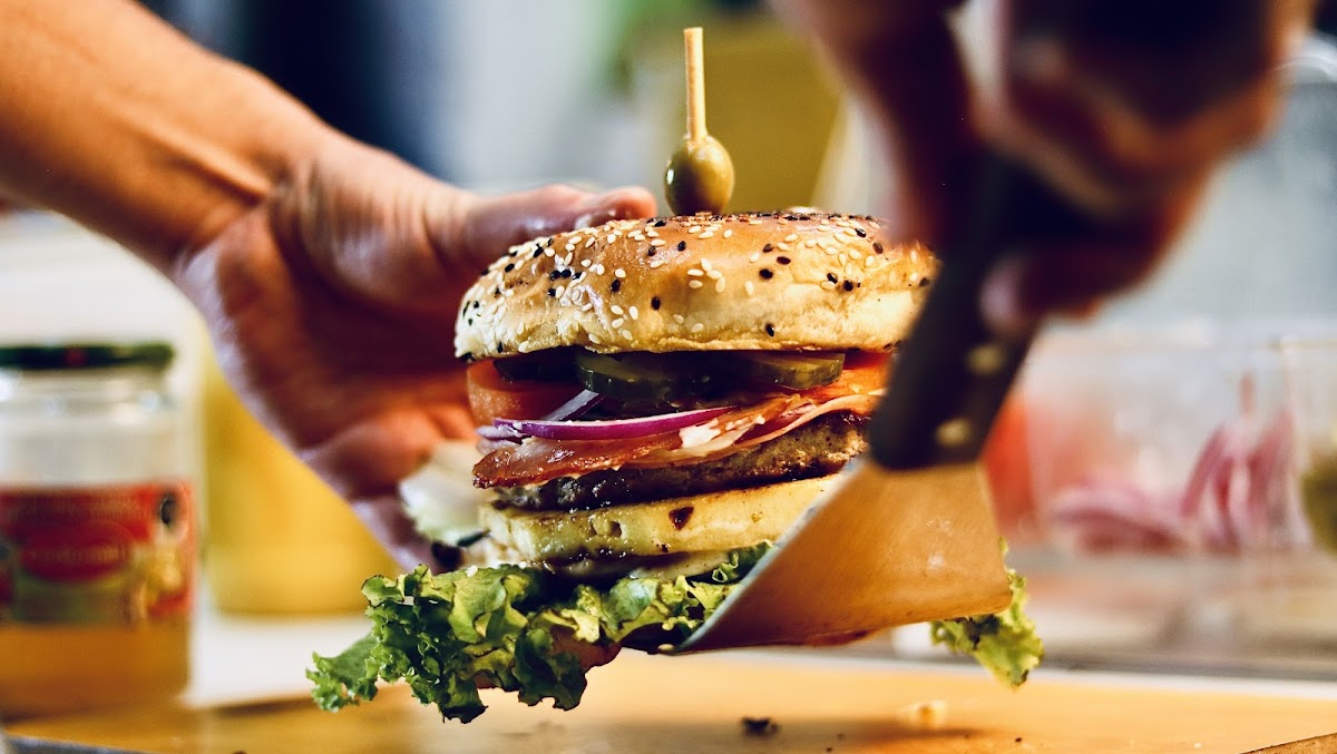 Interior of Pizzas Bro's with red walls and a counter of fresh pizza slices