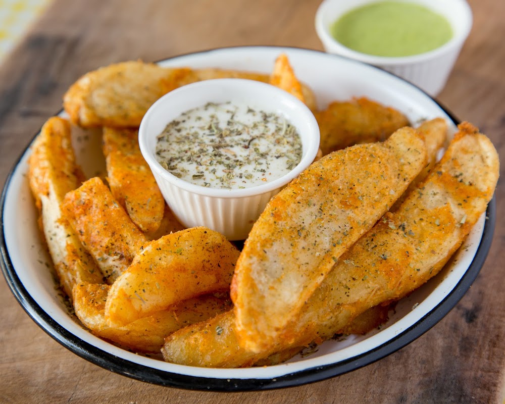 Exterior de Brothers Pizza a la Leña con iluminación cálida y horno de leña visible