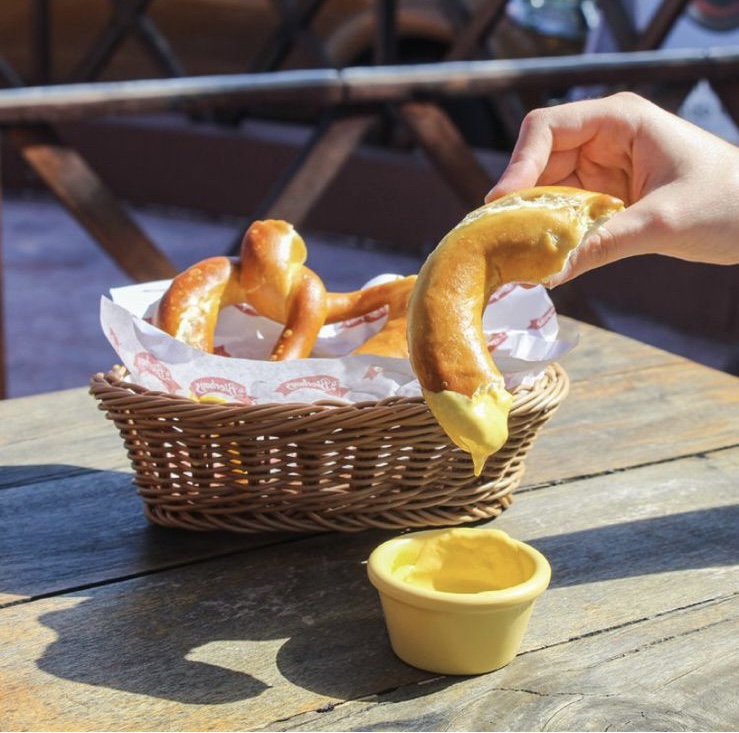 La Bierhaus's interior with wooden tables, hanging lights, and patrons enjoying beer.