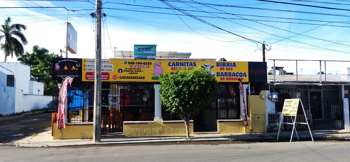Exterior de La Casa de Lalo en El Prado Chuburná, con su letrero rojo y la fila de clientes bajo la sombra de los árboles