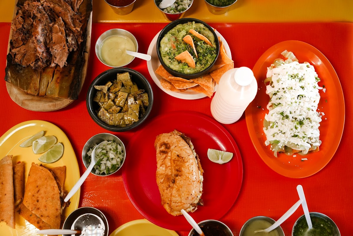 Interior shot of the wooden counter with chalkboard menu and a steaming pot of consome at La Casa de Lalo