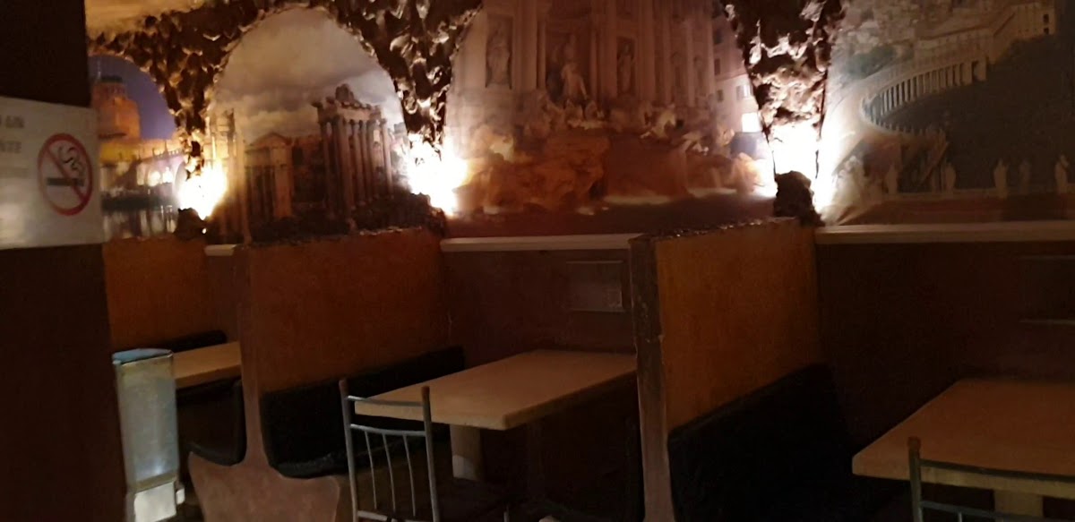 Antica Roma's candlelit patio with a plate of fettuccine and a glass of sangria