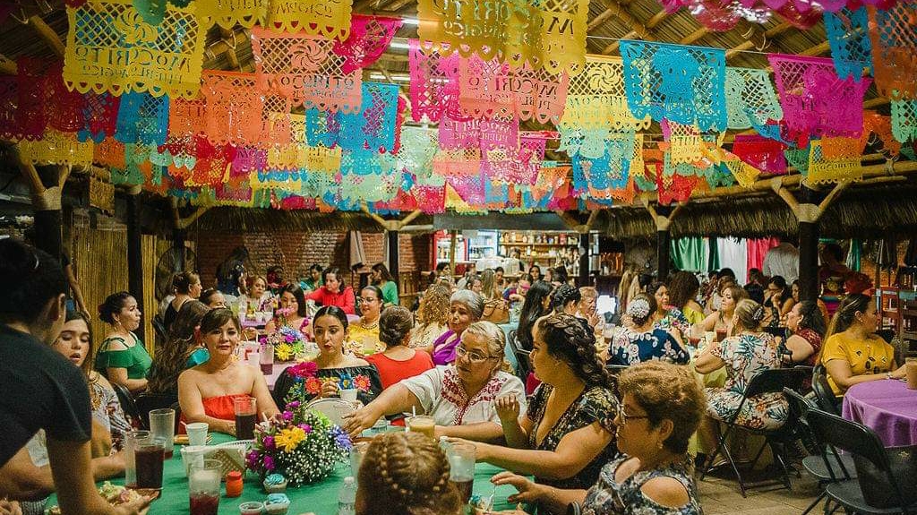 Mesa en La Puli Restaurante con tamales, pan dulce y un plato de chilorio, fondo de la calle Benito Juárez