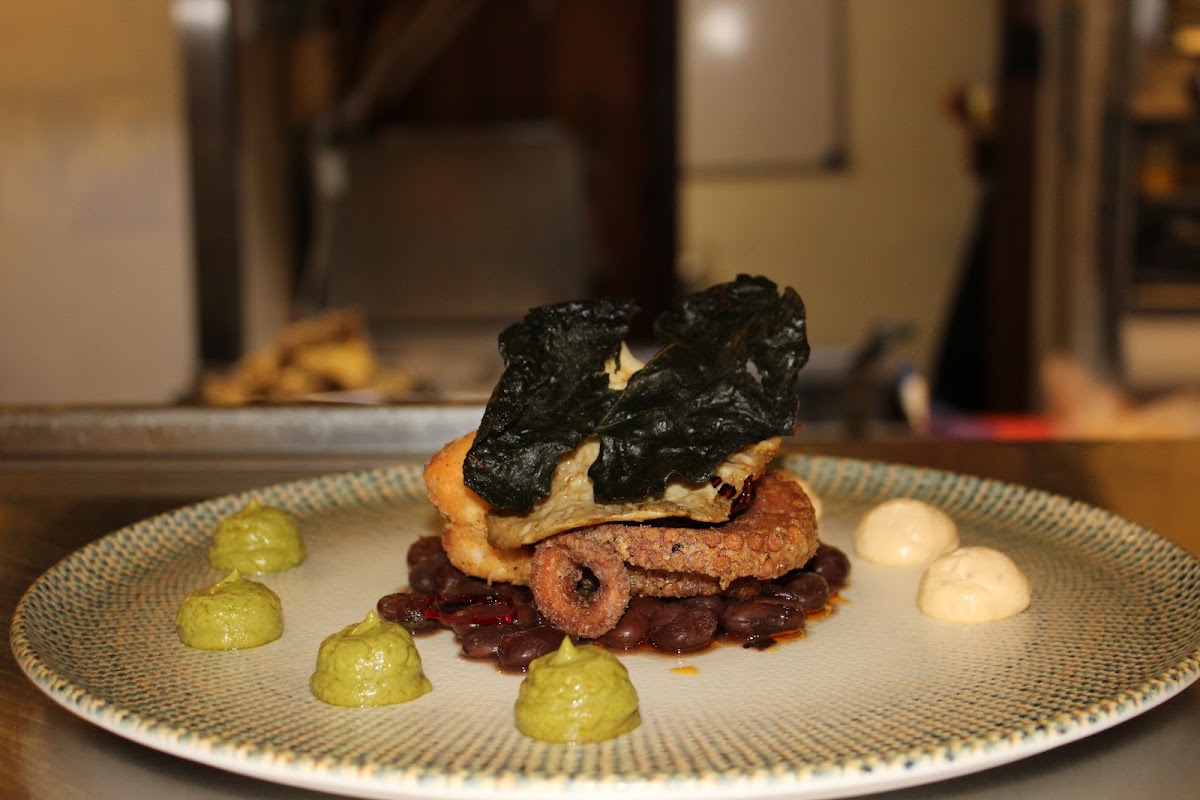 Vista de la terraza de Il Forno con pizza recién salida del horno y violín en el fondo