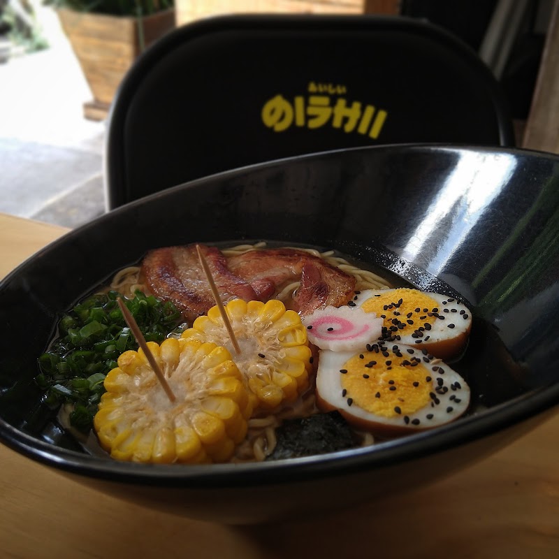 Close‑up of a colorful maki roll and a small miso soup bowl at Yoshoku (Los makis de hospitales), tabletop view