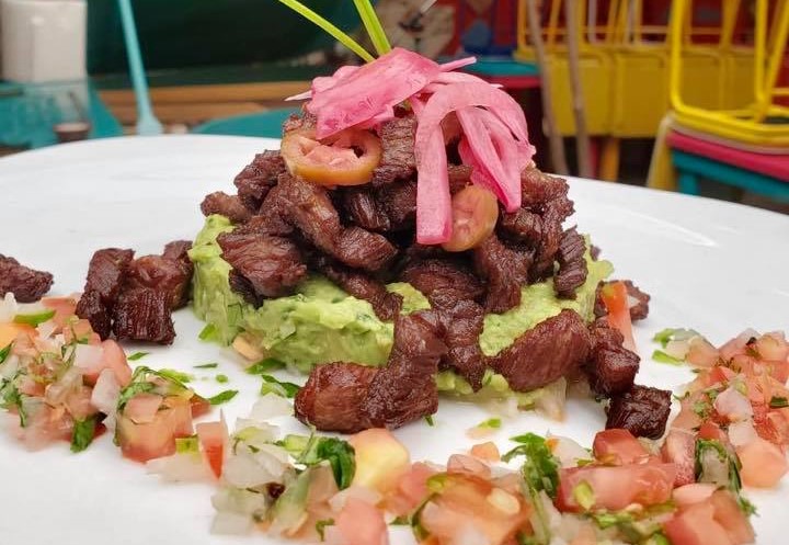 A vibrant pizza at Mi Lola Cocina de la Abuela