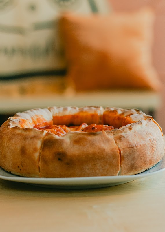 Mi Lola Cocina de la Abuela con una pizza casera servida en plato de cerámica, ambiente hogareño y decoración tradicional