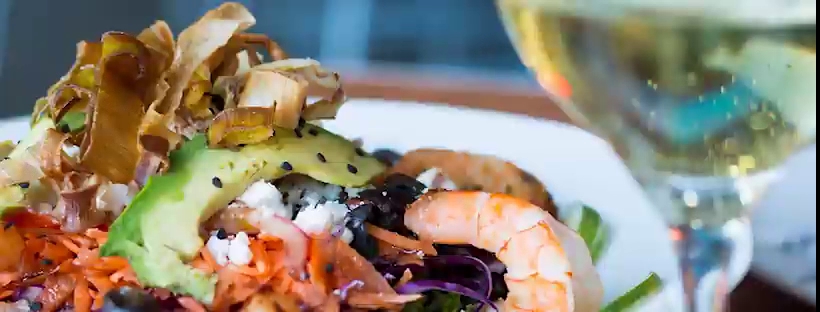 Mariscos Cocos Locos exterior con letrero iluminado y mesas al aire libre, mostrando una bandeja de aguachile y camarones al vapor