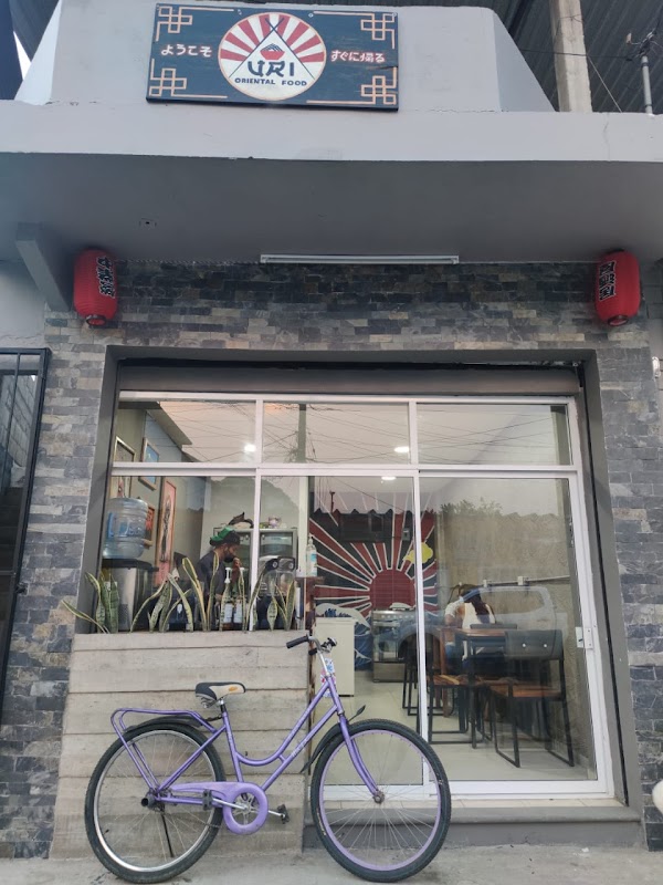 Vista exterior de La Carreta con su fachada junto al río, clientes disfrutando del desayuno