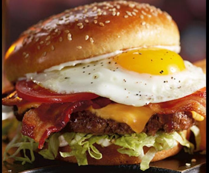 Hamburguesa buffalo de Fatima's Grill con papas crujientes al lado, tomada en la barra del restaurante