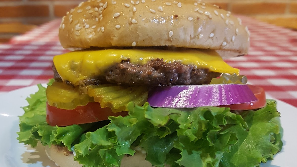 Interior de Fatima's Grill SLP con hamburguesas y mesas de madera