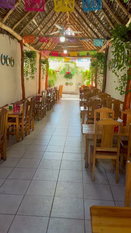 El Quetzal de Laura con un plato de enchiladas de camarón y una copa de mezcal al lado