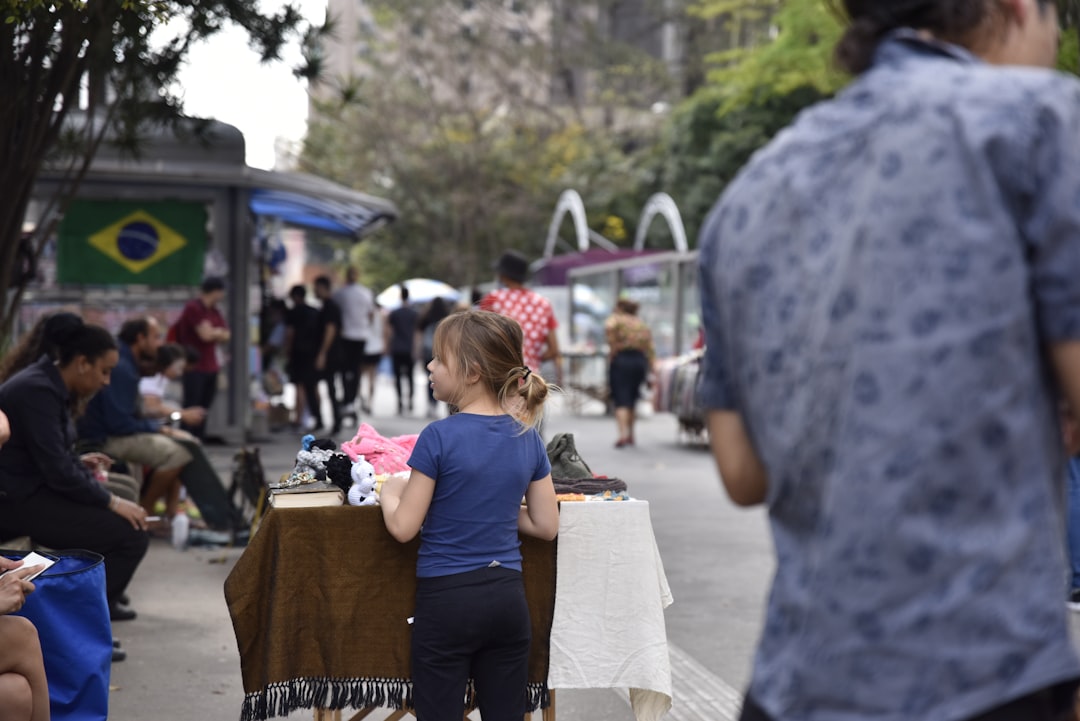 a little girl standing in front of a table