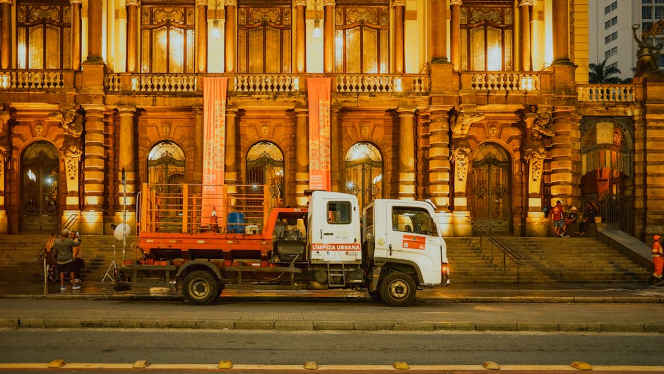 Front view of the Municipal Theatre in São Paulo, Brazil, illuminated at night with an urban cleaning truck parked in front.