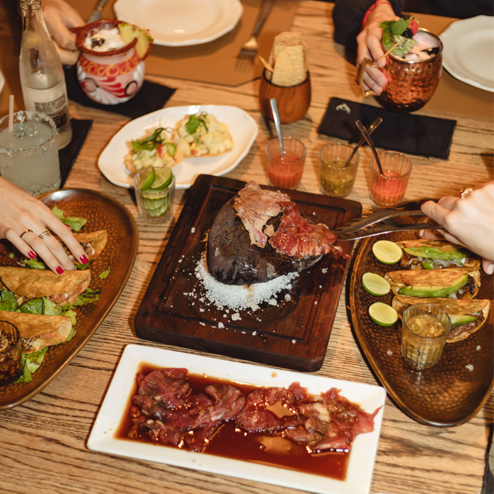 Menudería Guadalajara Otay – fachada colorida con letrero y una mesa de carne en su jugo y tortillas al frente